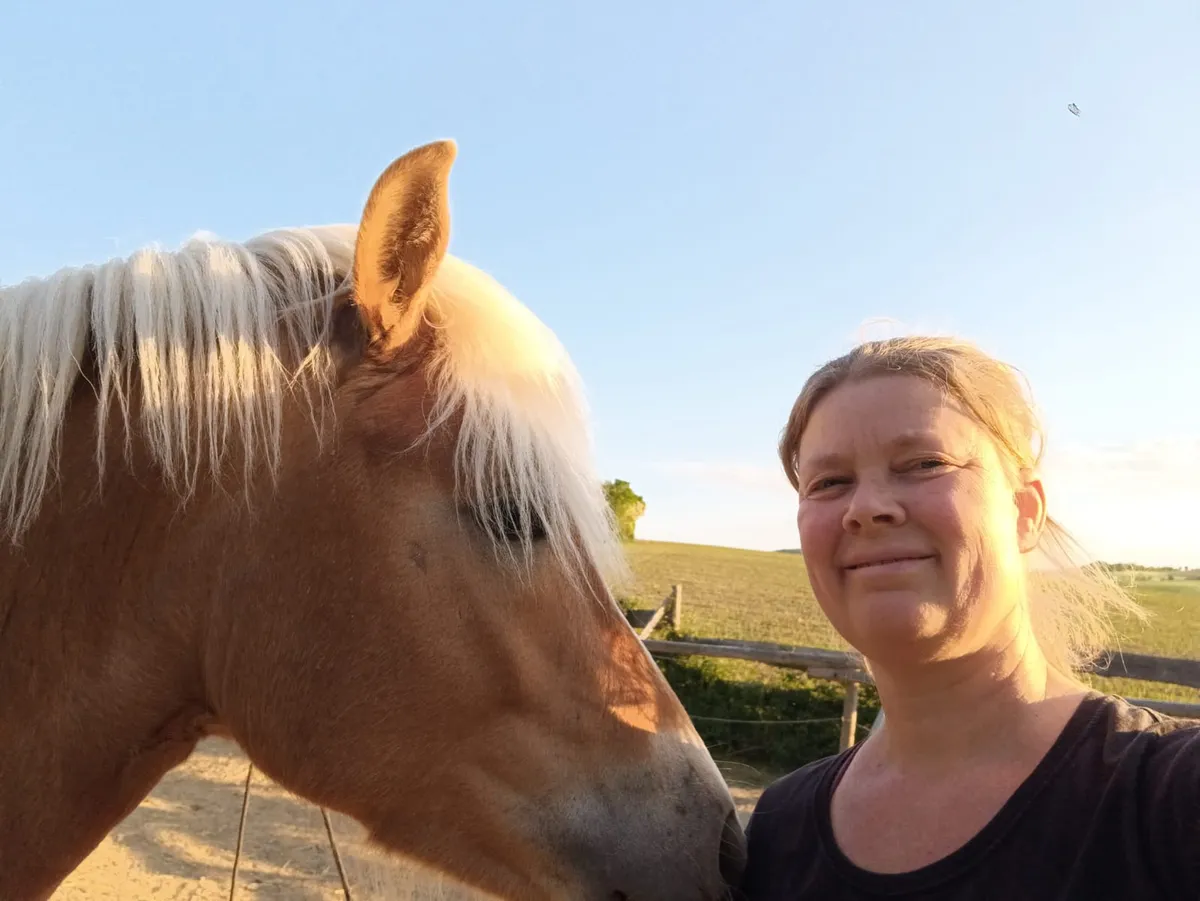 Doris und ihr Pferd Kopf an Kopf in der Abendsonne
